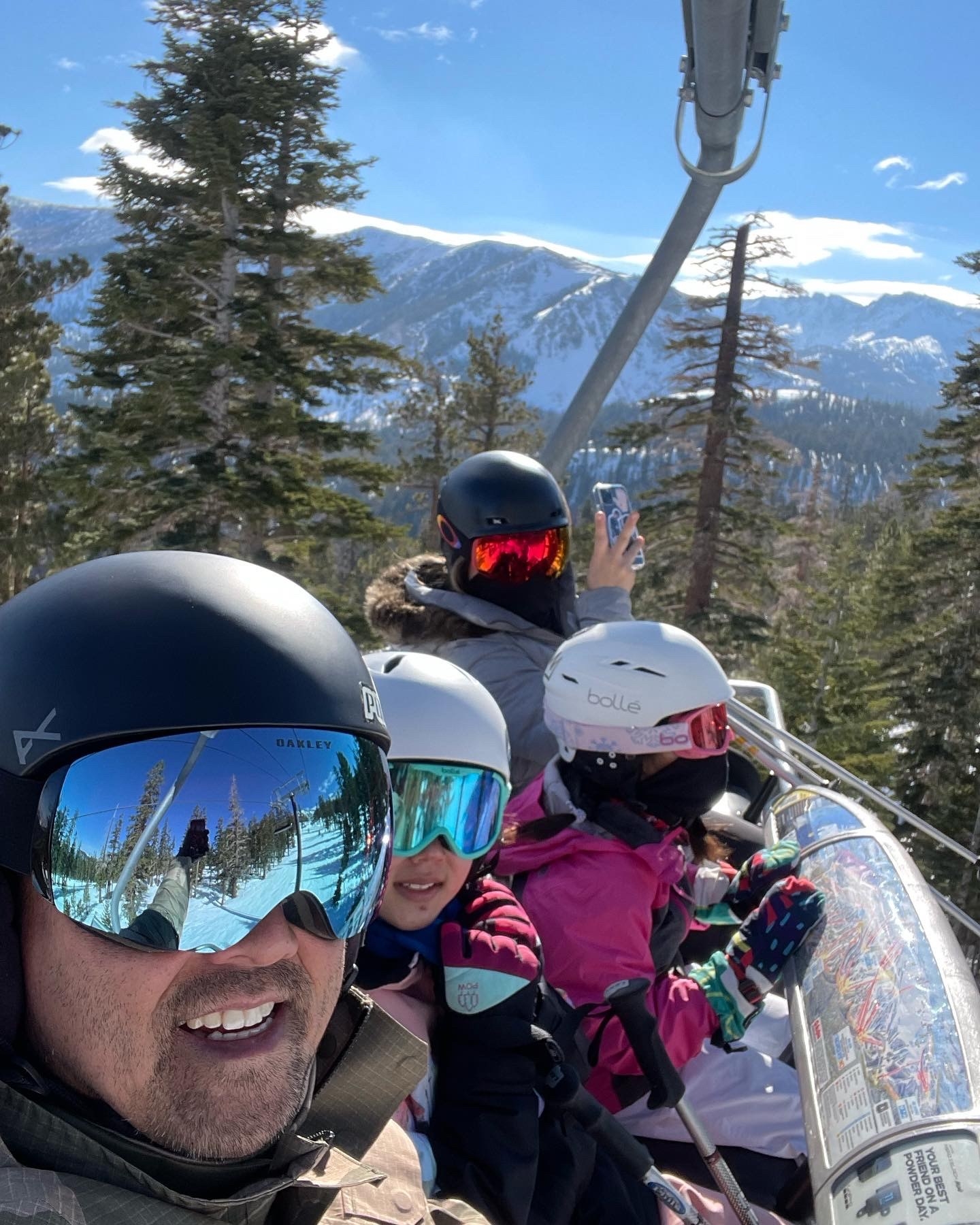 Family on a ski lift taking a selfie