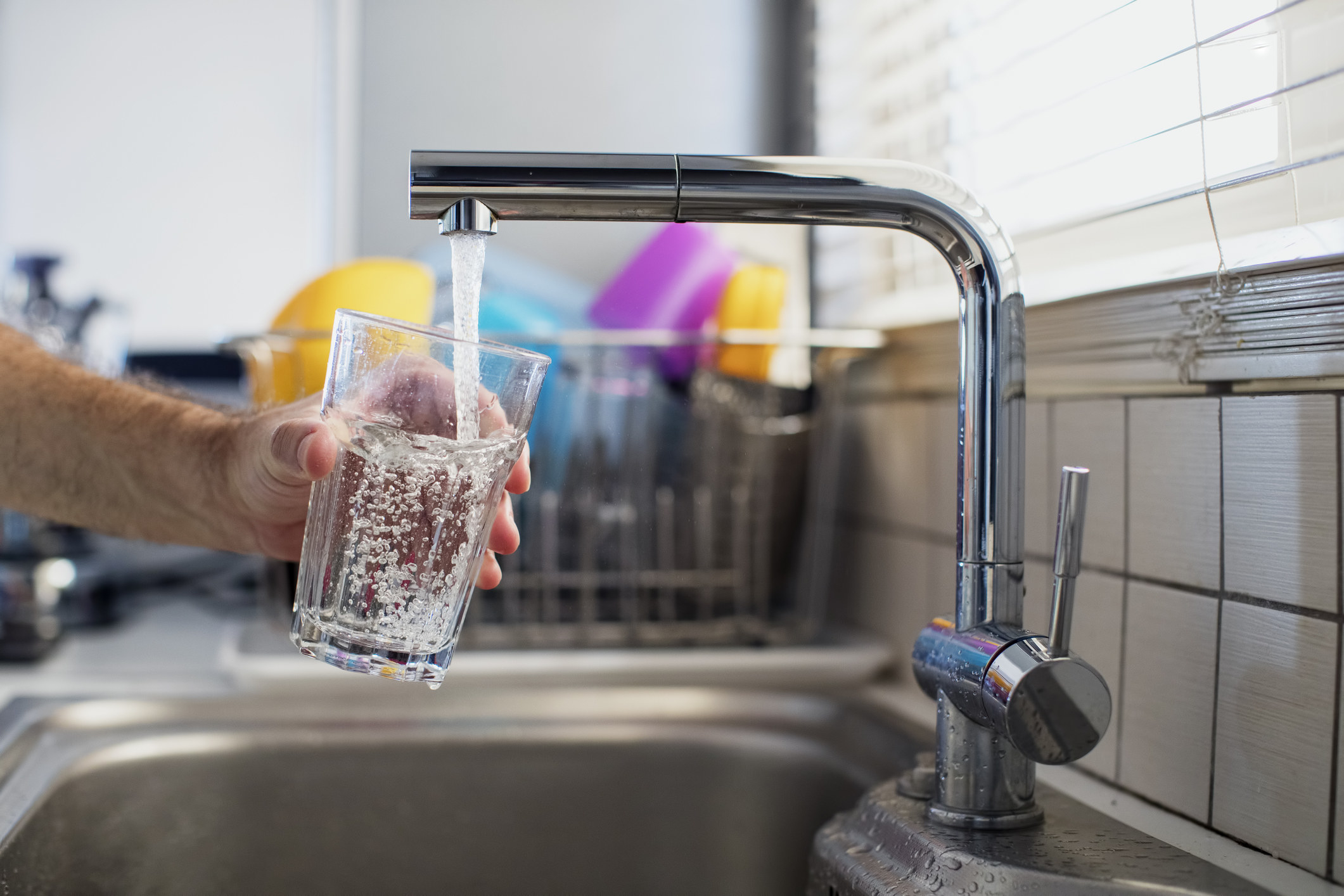 A person pouring water from the faucet