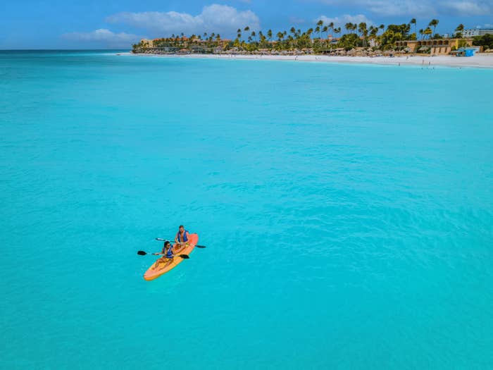 Two people kayaking on clear ocean water