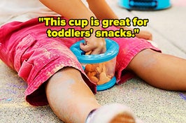 A child model's hand pulling a cracker out of the blue snack cup and text that reads "This cup is great for toddlers' snacks"