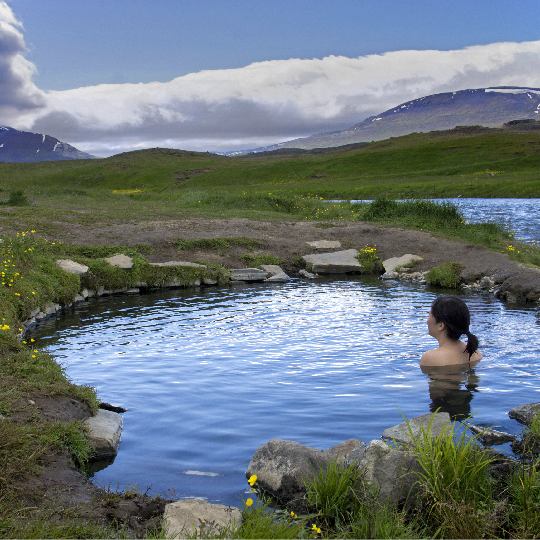 A woman sitting in a hot spring.