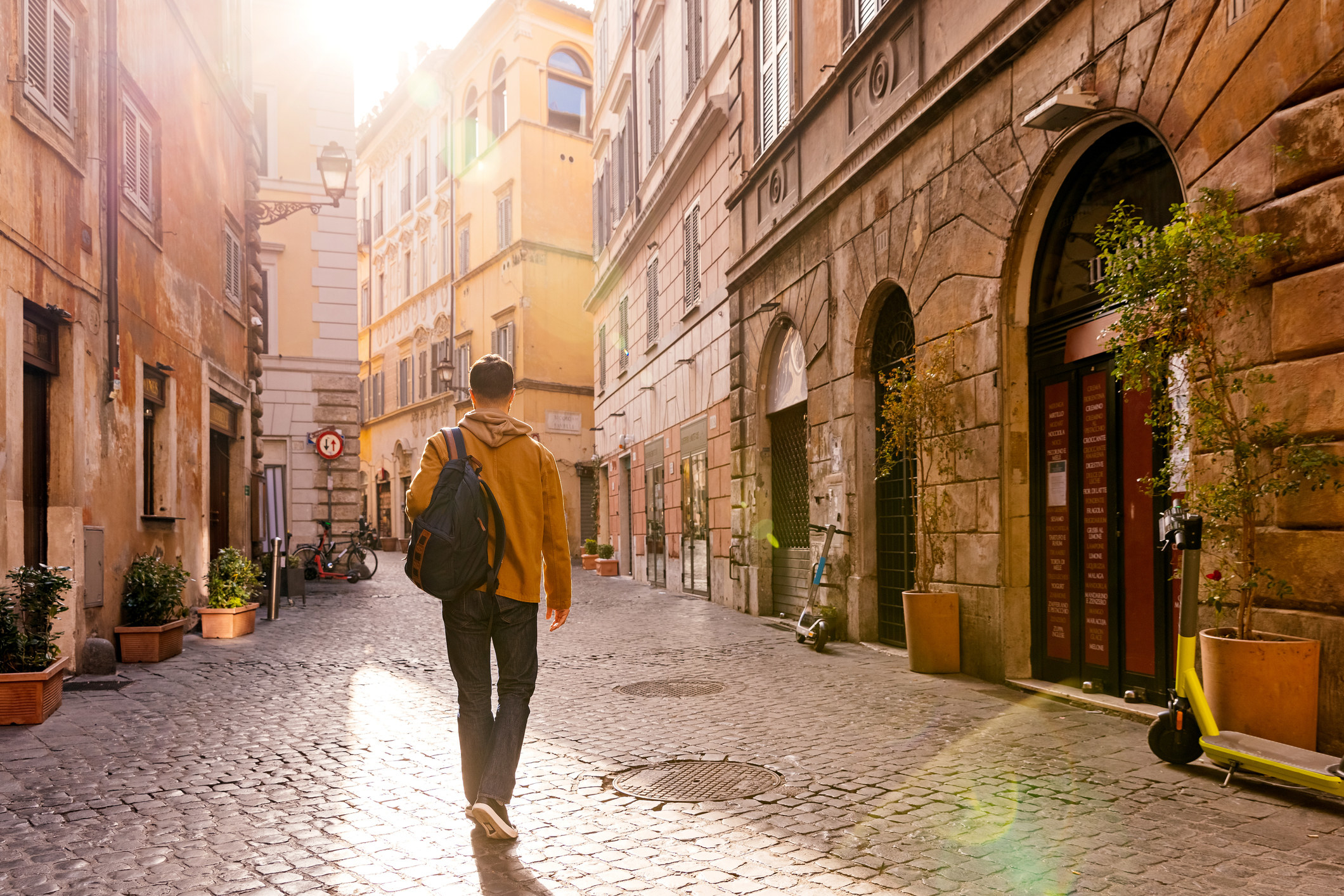 A man walking on a quiet street in Rome.