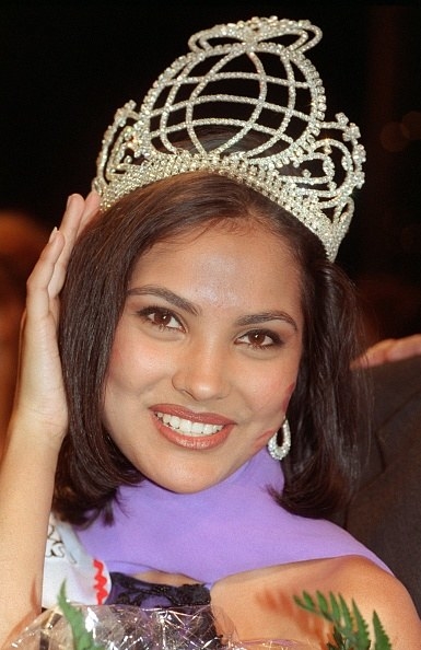 Lara Dutta holds her crown and smiles