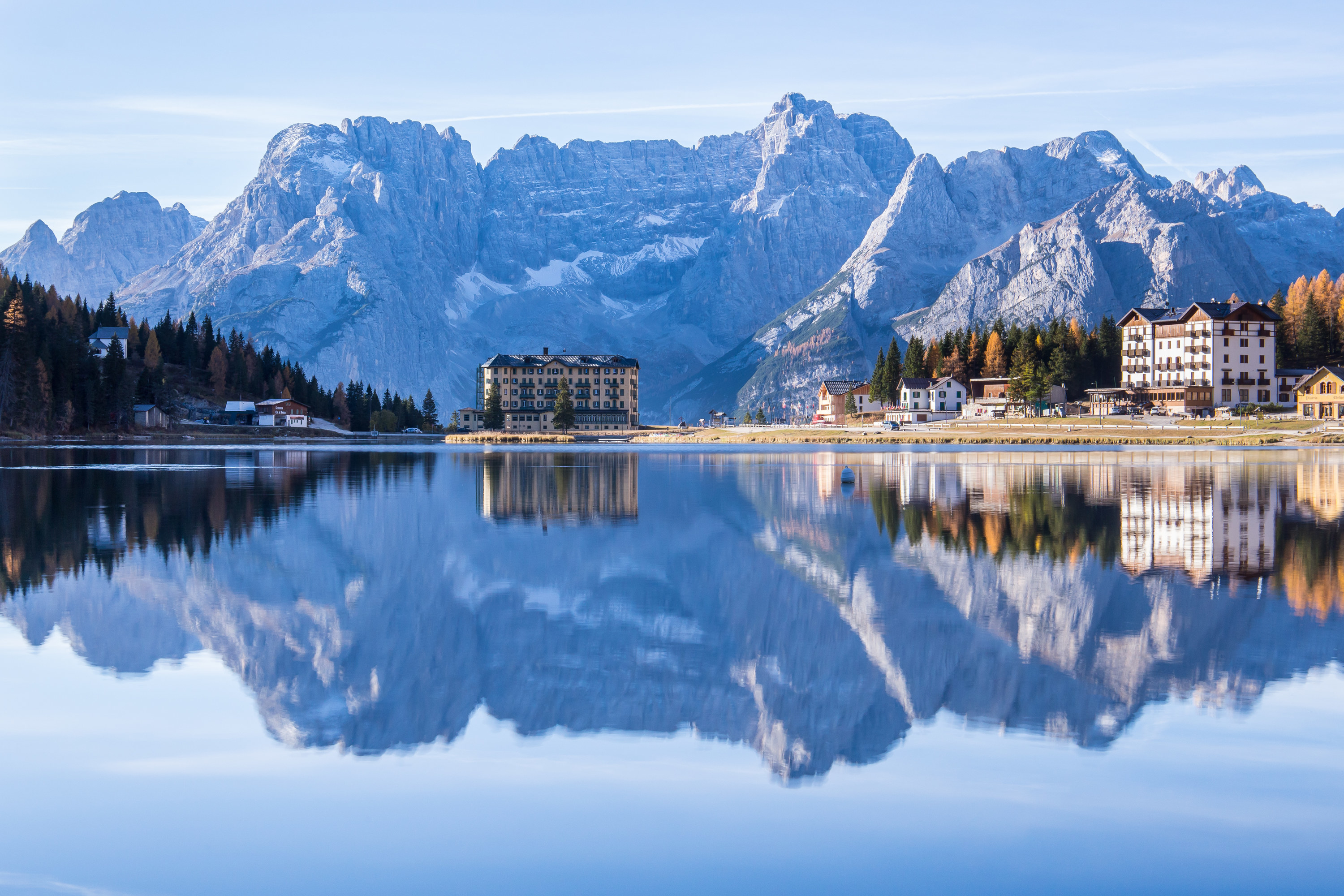 Jagged apl mountains reflected in a clear lake with swiss buildings