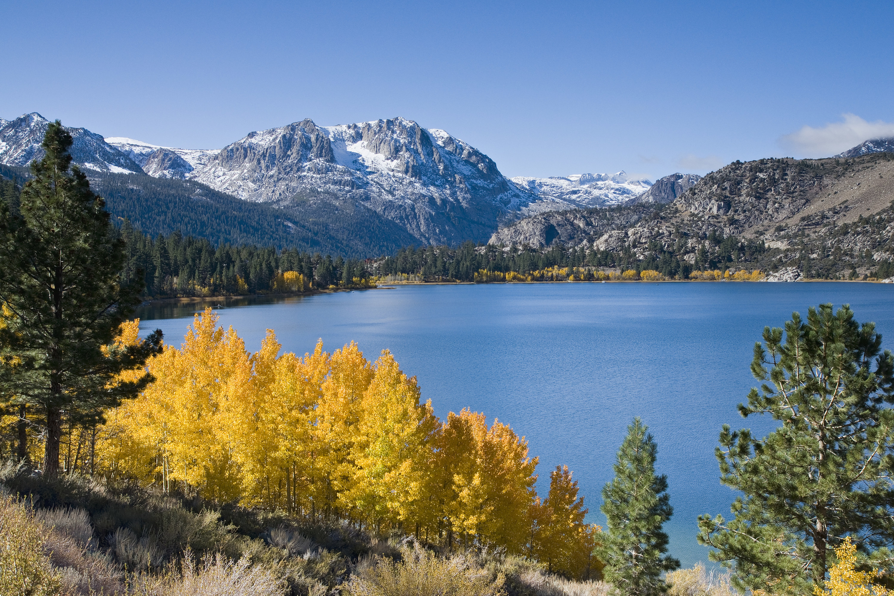 Lake under mountains with yellow and green foliage, June lake, California.