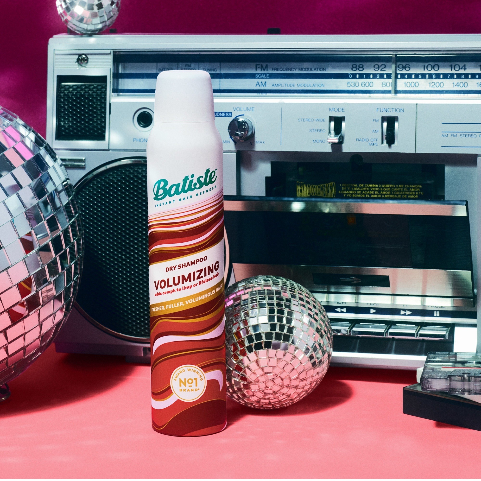 the bottle of dry shampoo next to a boombox and disco balls