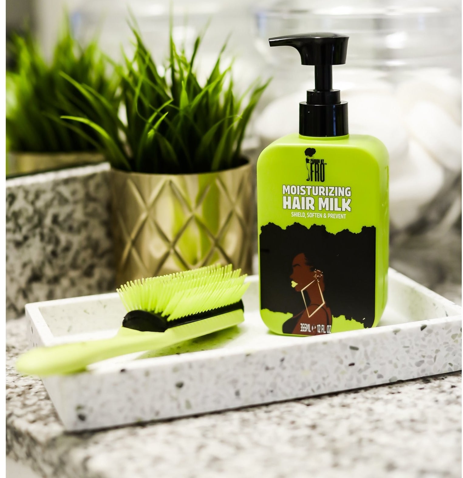 The hair milk product next to a matching comb on a bathroom sink.