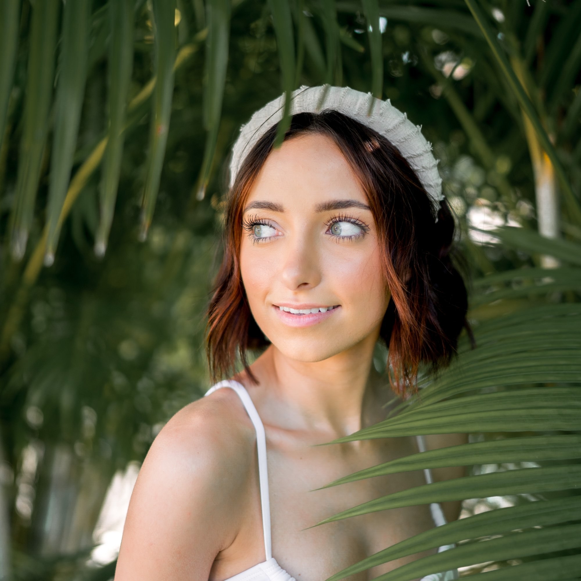 A model wearing the headband in a tropical scene
