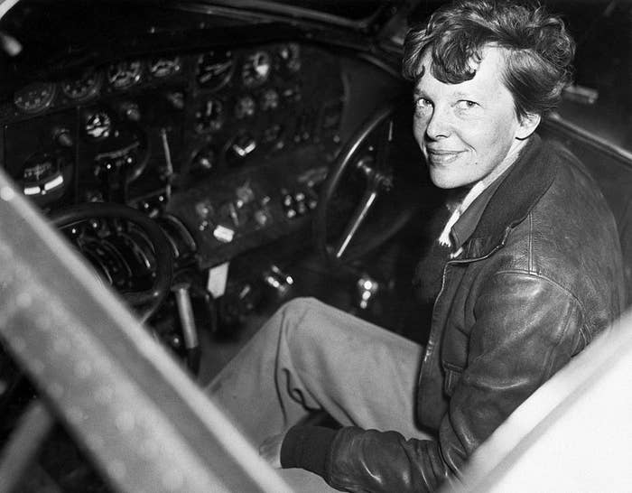 Amelia Earhart sitting in the cockpit of her plane