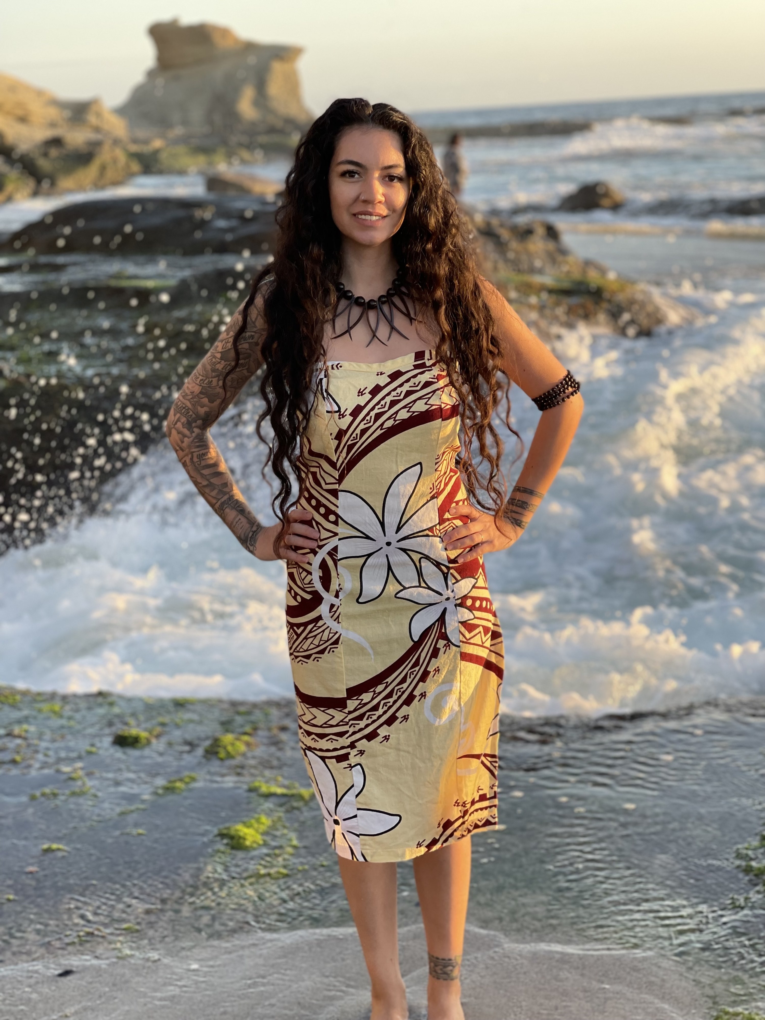 Morgan standing by the sea in a traditional dress