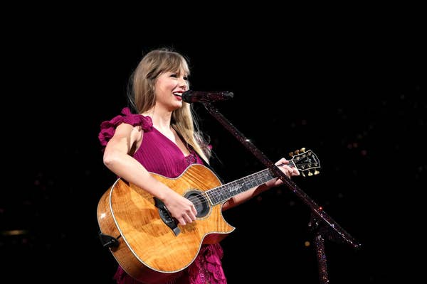playing the guitar while wearing a purple tiered dress