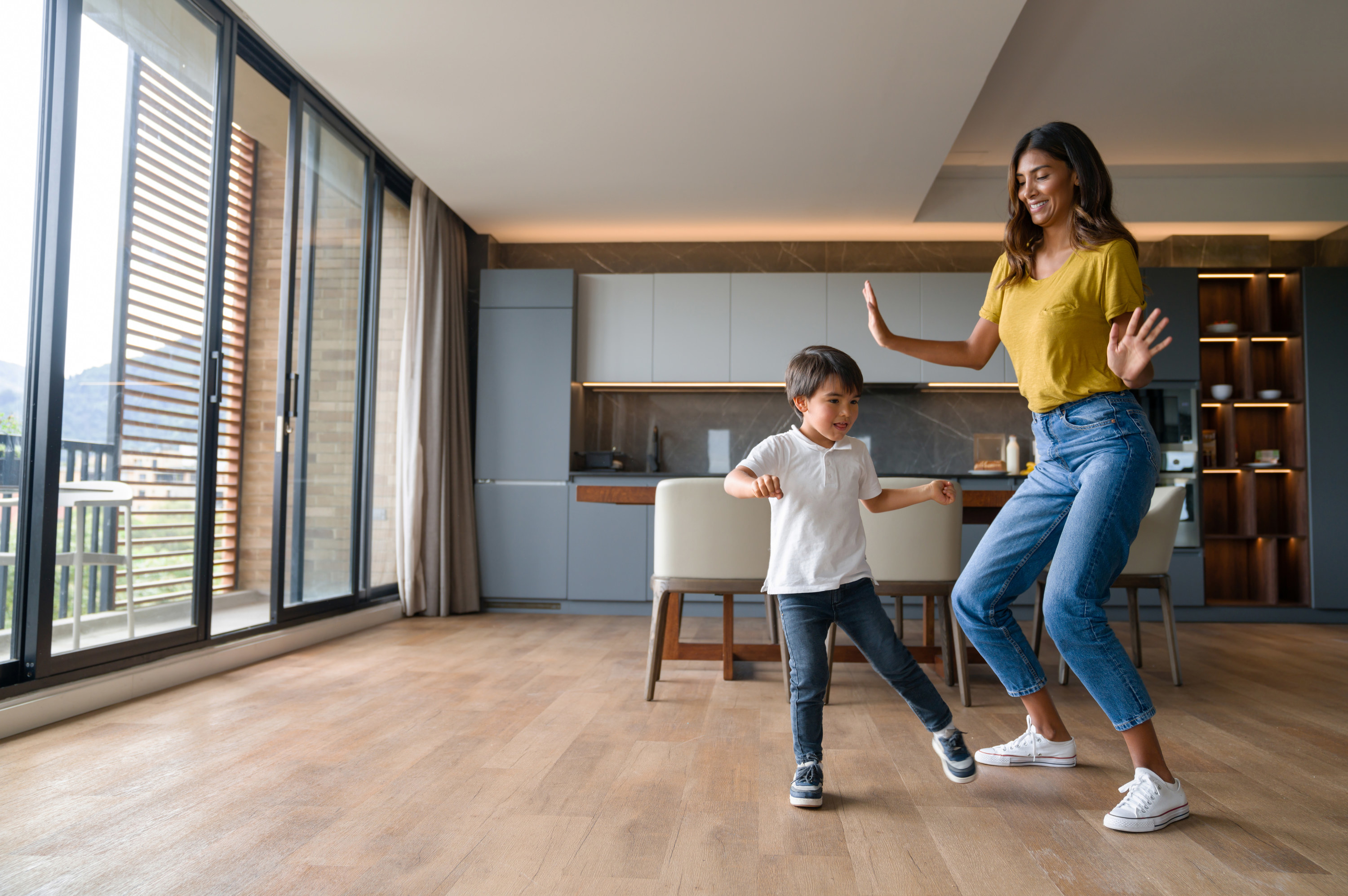 A woman dances with a young child at home