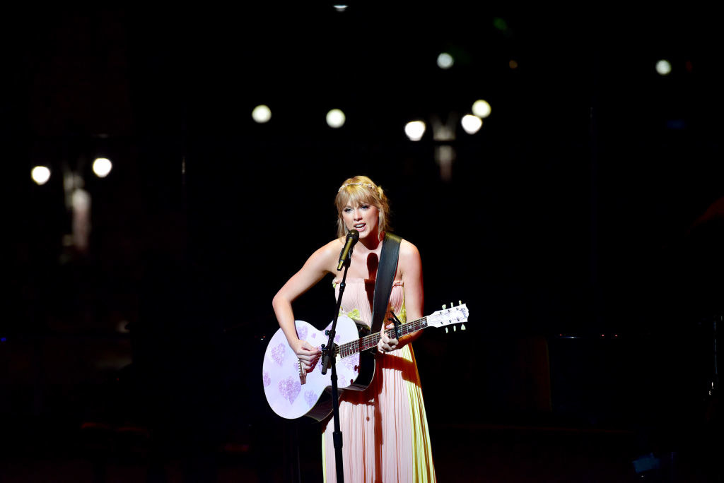 taylor singing and playing guitar on stage