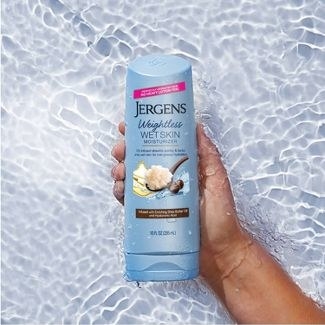 A person holding a bottle of in-shower lotion