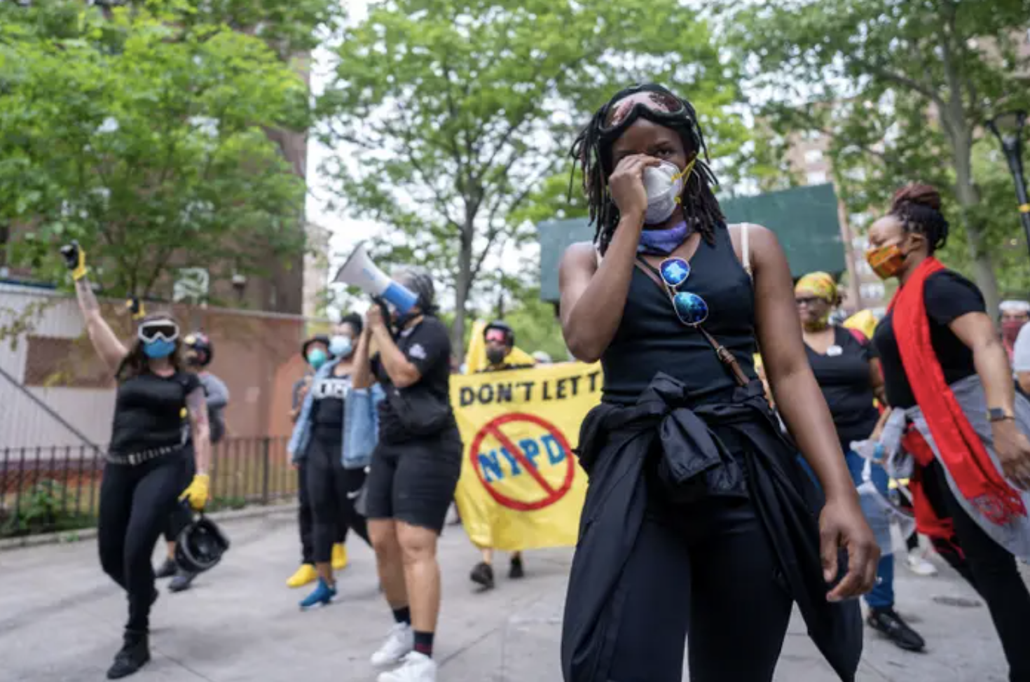 Protesters walk through Mott Haven, New York holding posters and a megaphone