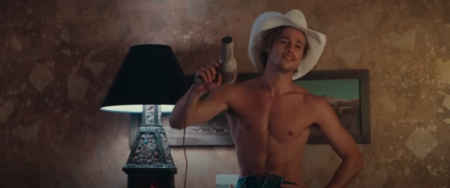 A shirtless man in a cowboy hat