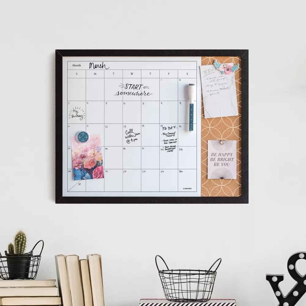 The dry erase calendar hanging on a wall