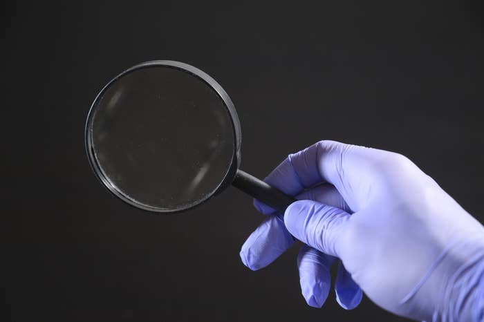 a magnifying glass in a gloved hand