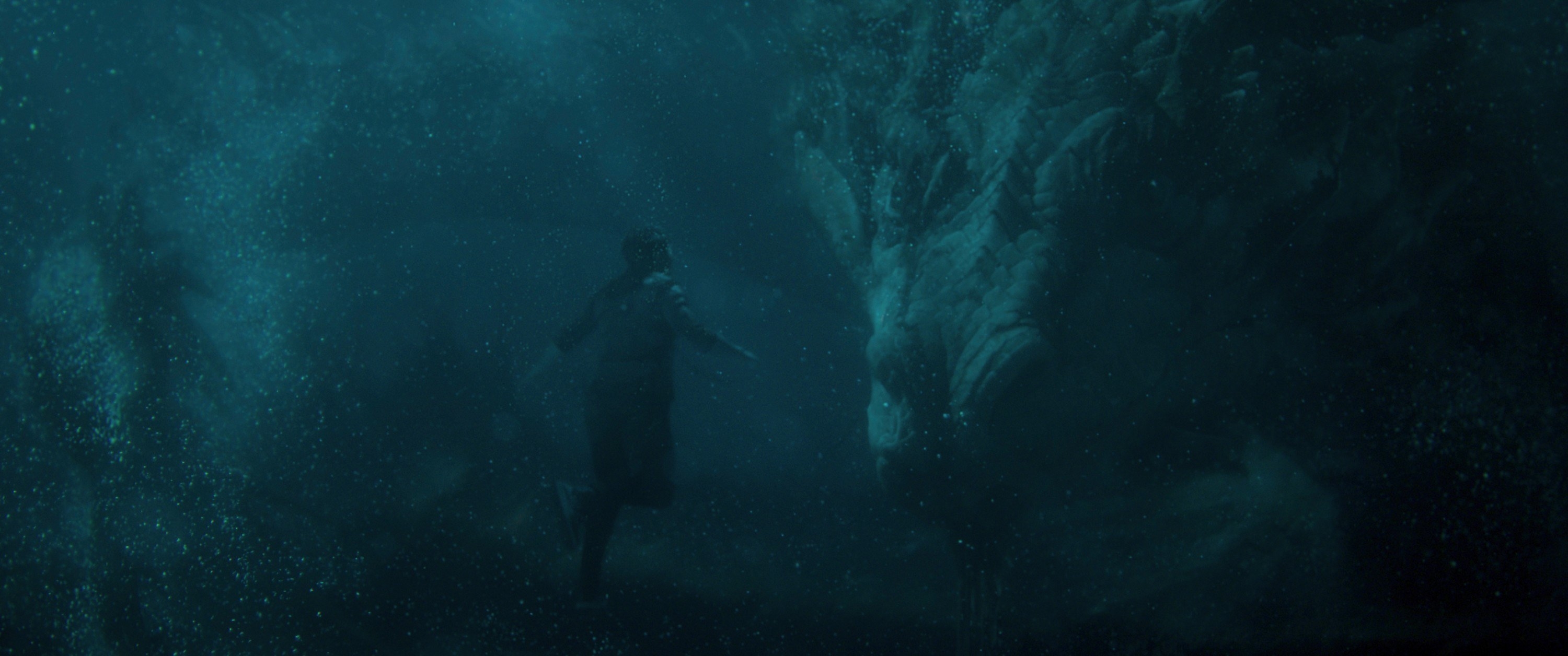 A man swims with a dragon underwater