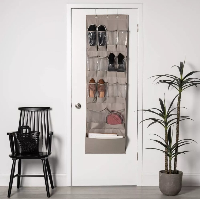 Over the door shoe organizer next to a plant and a black chair