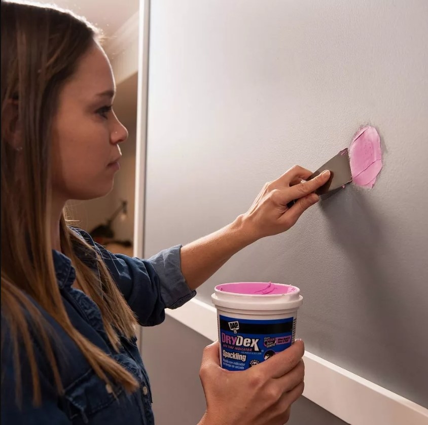 Woman using Drydex spackling on the wall