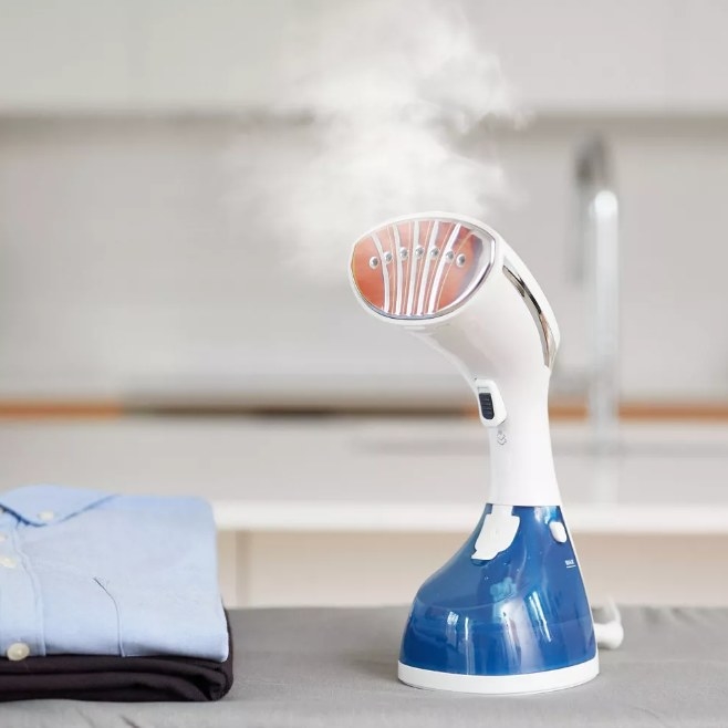 Handheld steamer with steam coming out of it