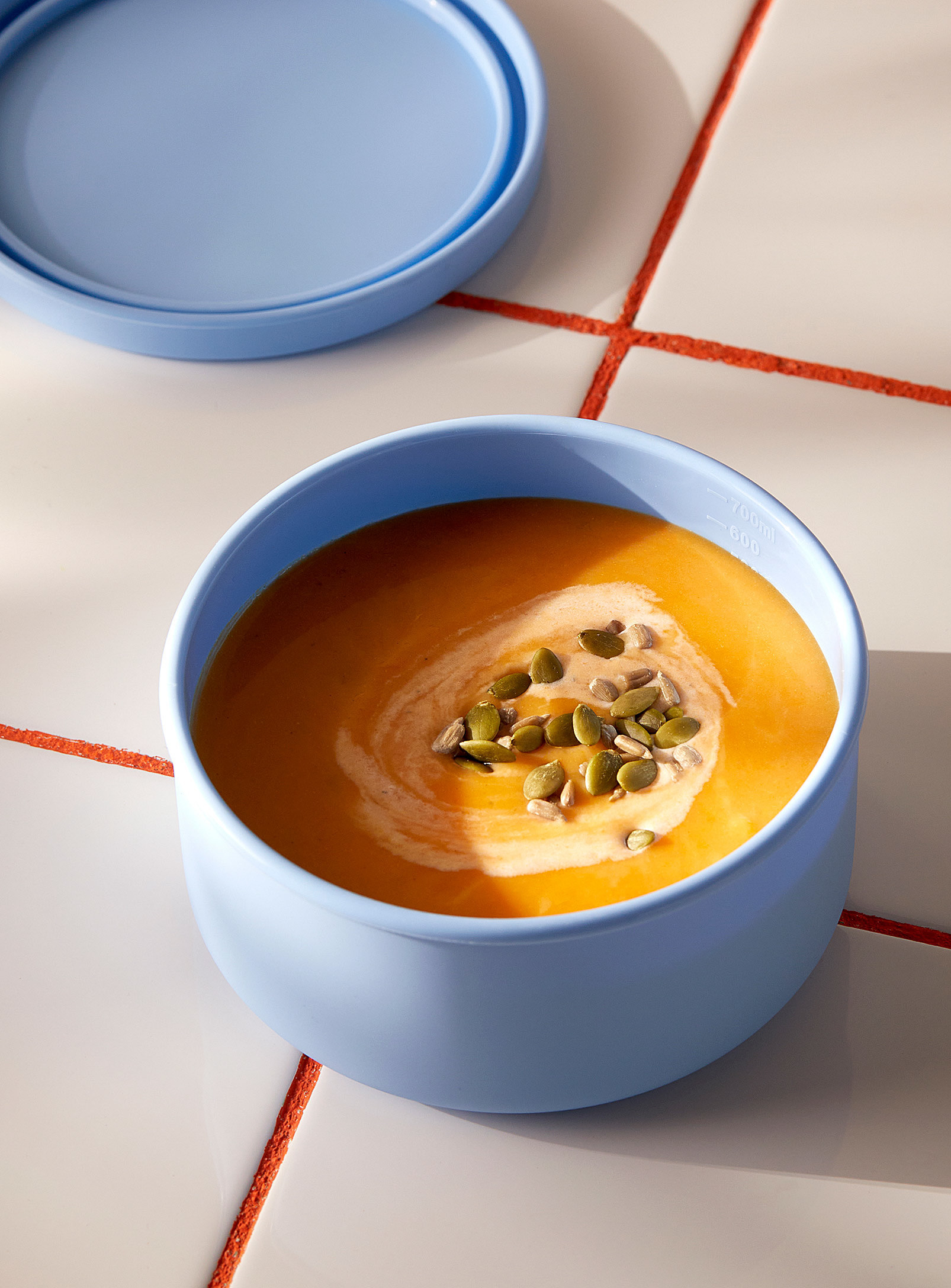 a silicone circular bowl filled with butternut squash soup