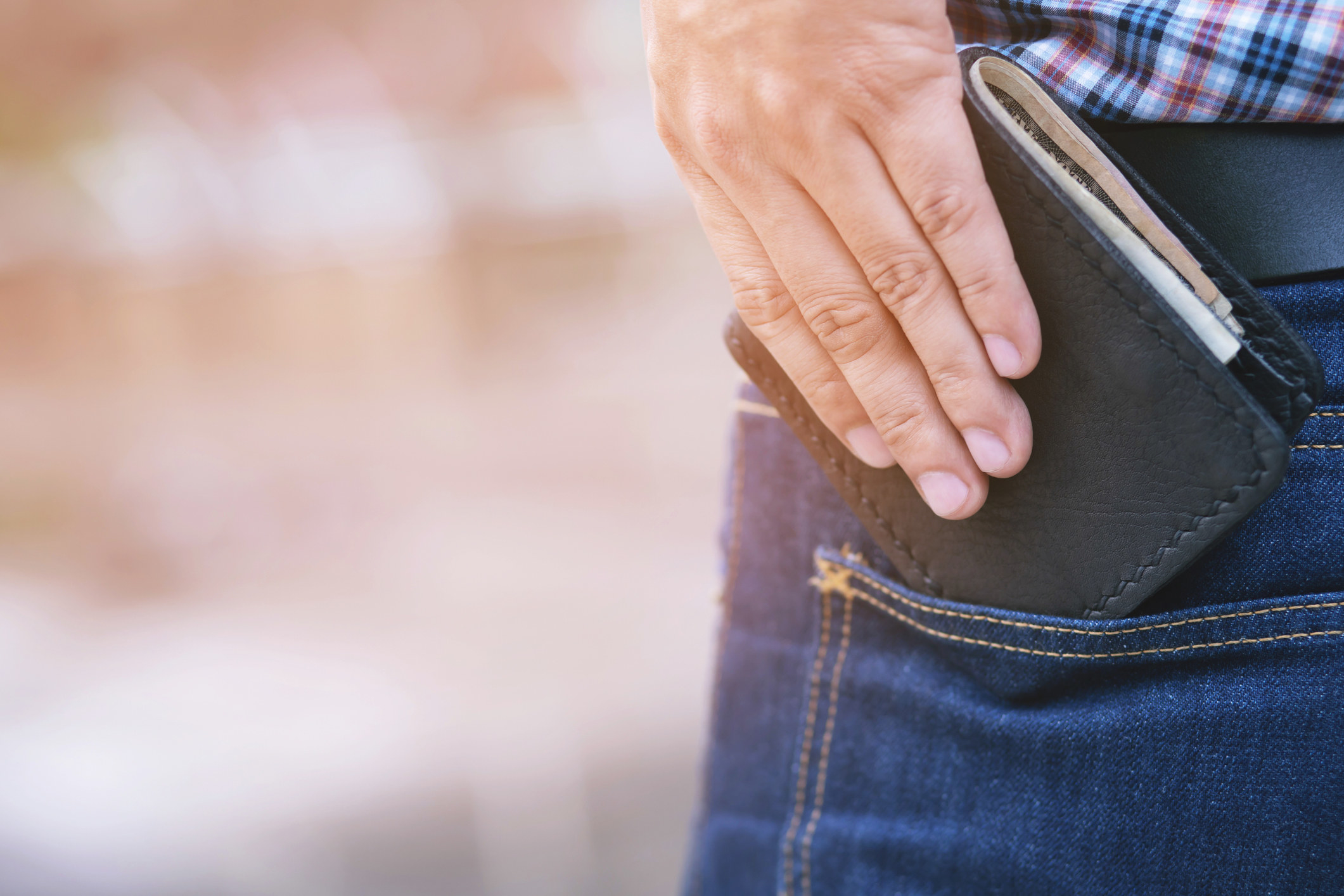 A man putting a wallet into his pocket.