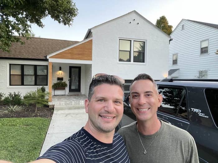 Selfie of Jared and Tim smiling in front of a house
