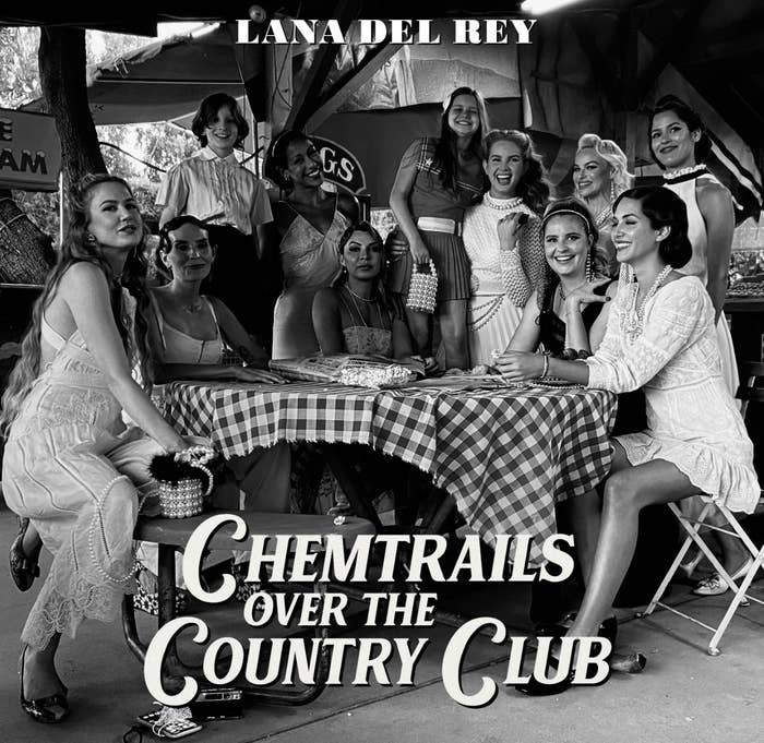 album cover for &quot;Chemtrails Over the Country Club,&quot; where a group of about 12 women wear dresses, around a round table with a checkered tablecloth over it