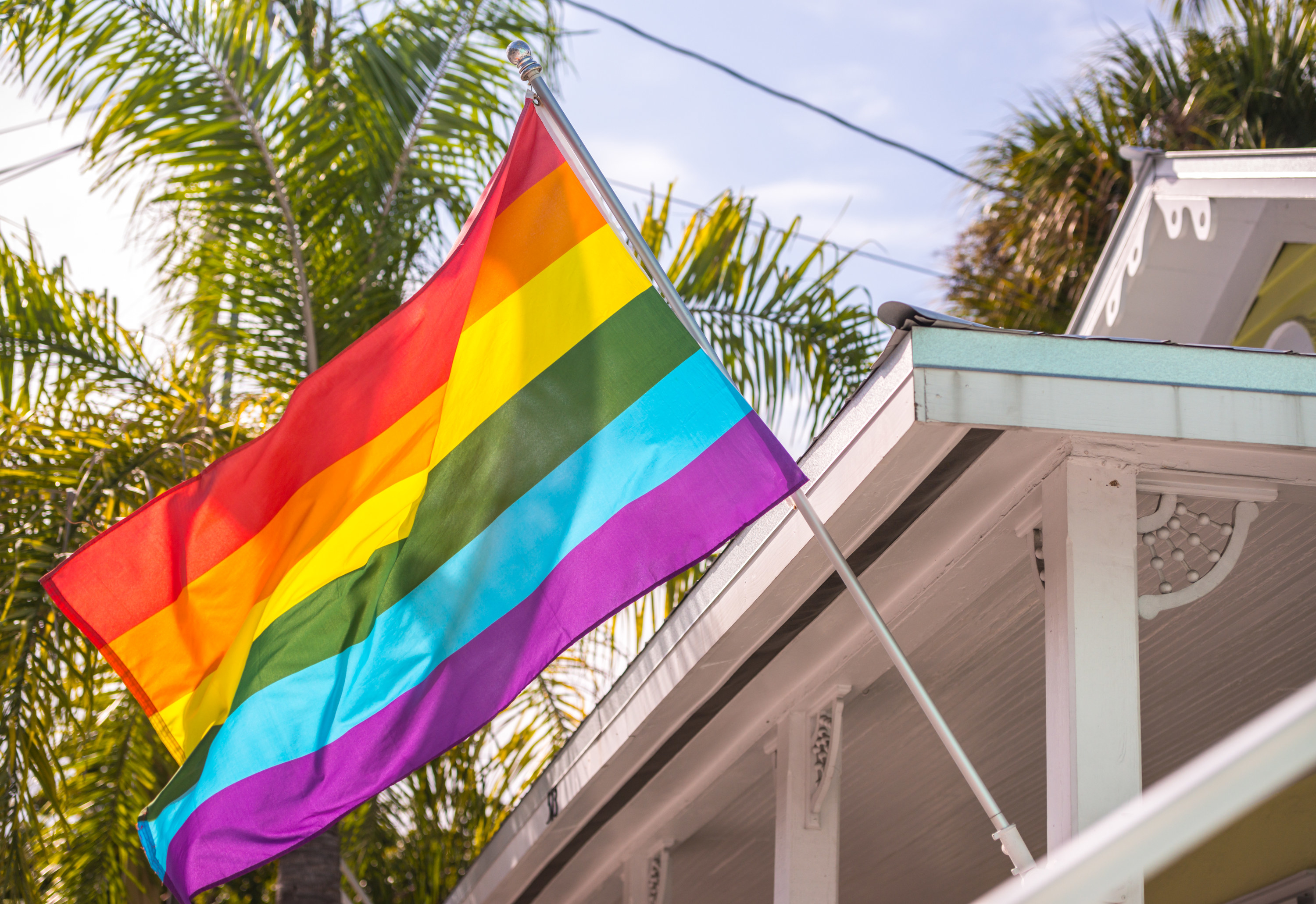 A pride flag hanging outside a house