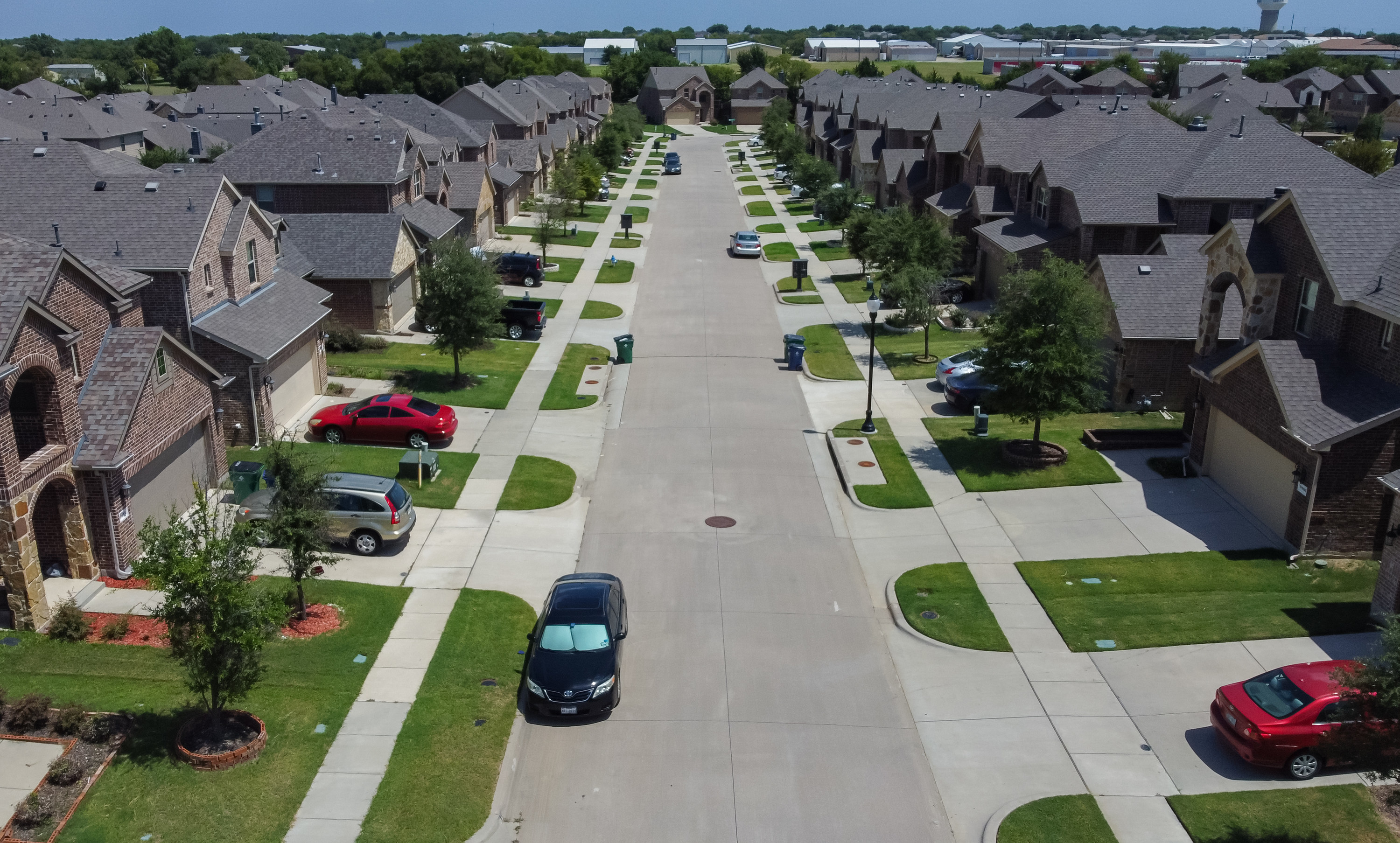 Aerial view of community homes with plants and cars in McKinney