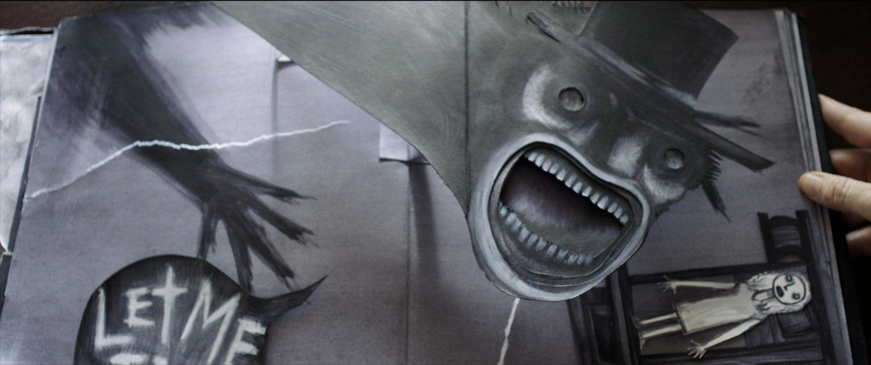 A terrifying black-and-white pop-up book features a screaming monster