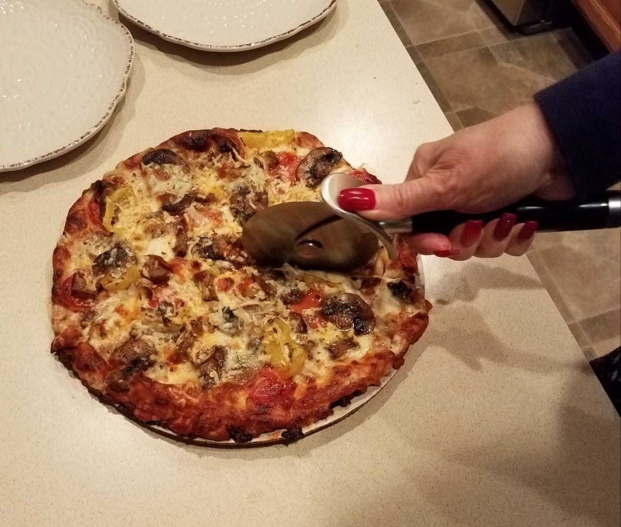 Reviewer slicing pizza with the cutter