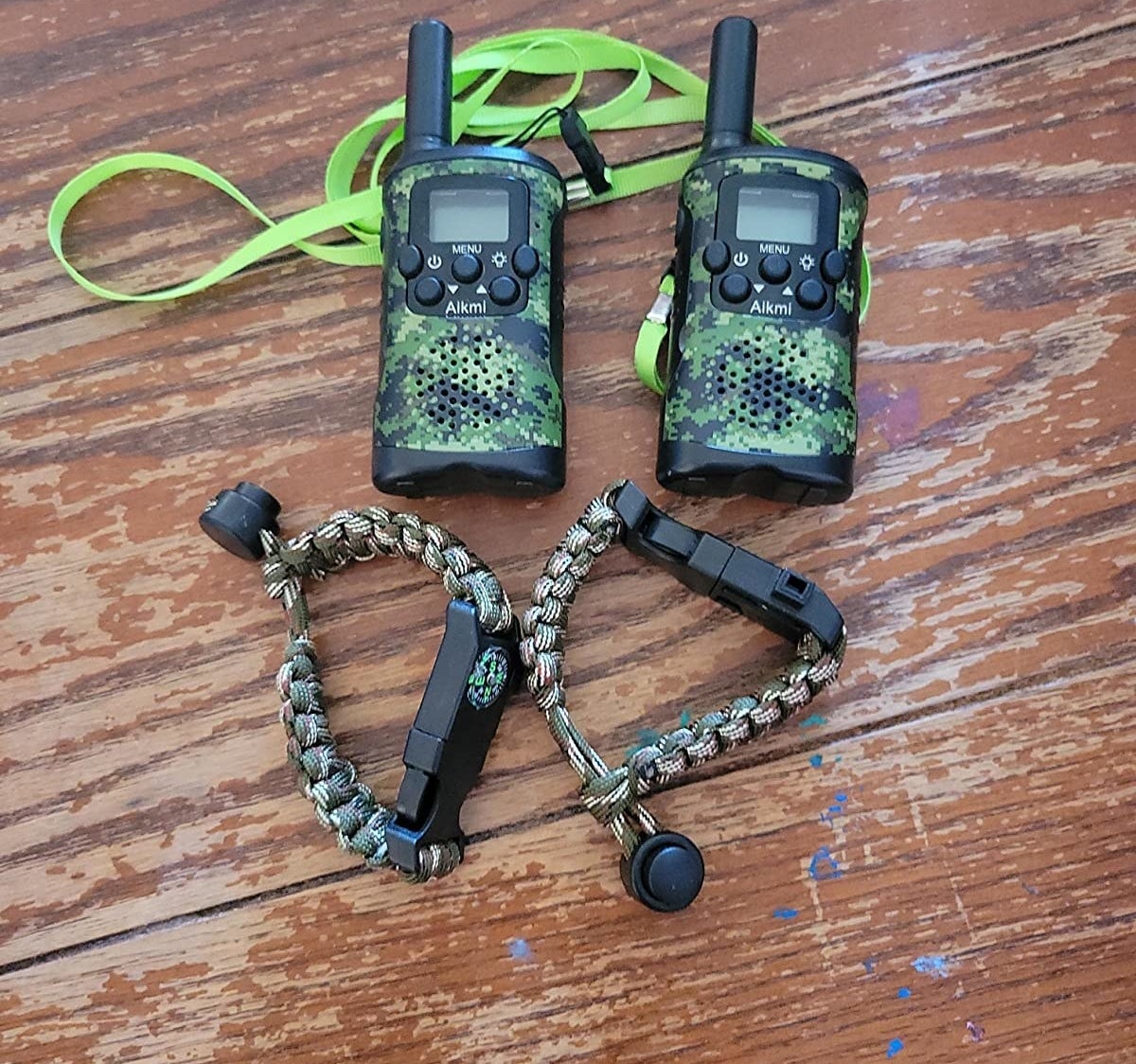 Reviewer&#x27;s photo of pair of black and camouflage walkie talkies and compass bracelets