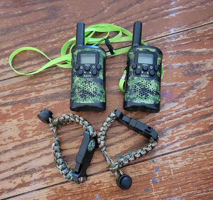 Reviewer&#x27;s photo of pair of black and camouflage walkie talkies and compass bracelets