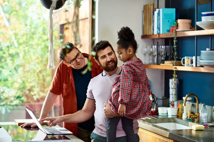 a couple holding their child in the kitchen