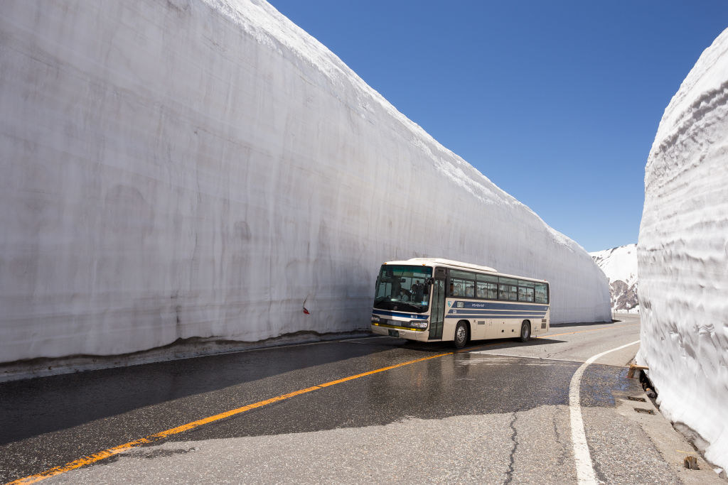 bus next to the tall snow wall