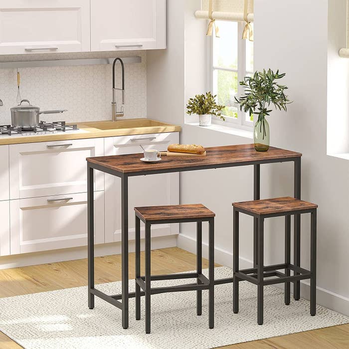 the table and stools in a kitchen by a window