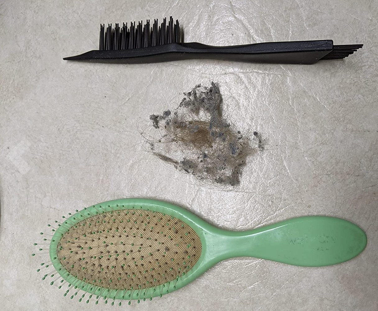 The product next to a hair ball and a green brush