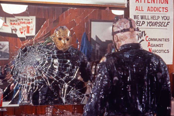 Jason Voorhees stares at a shattered mirror while covered in slime