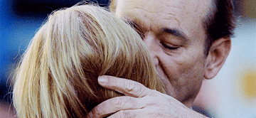 Bill Murray holds Scarlett Johanason tenderly and whispers in her ear.