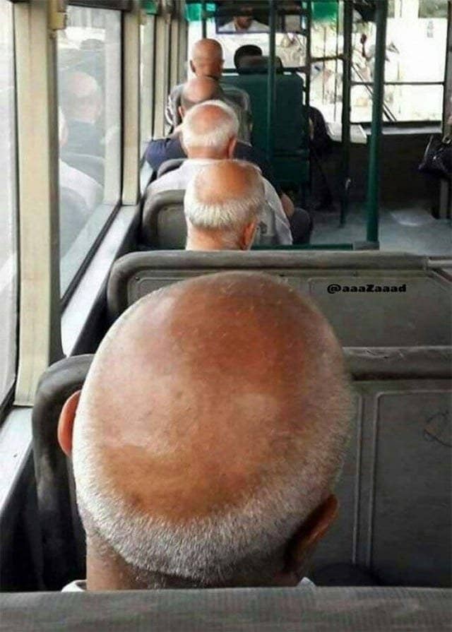 Bald men sitting behind each other on a bus