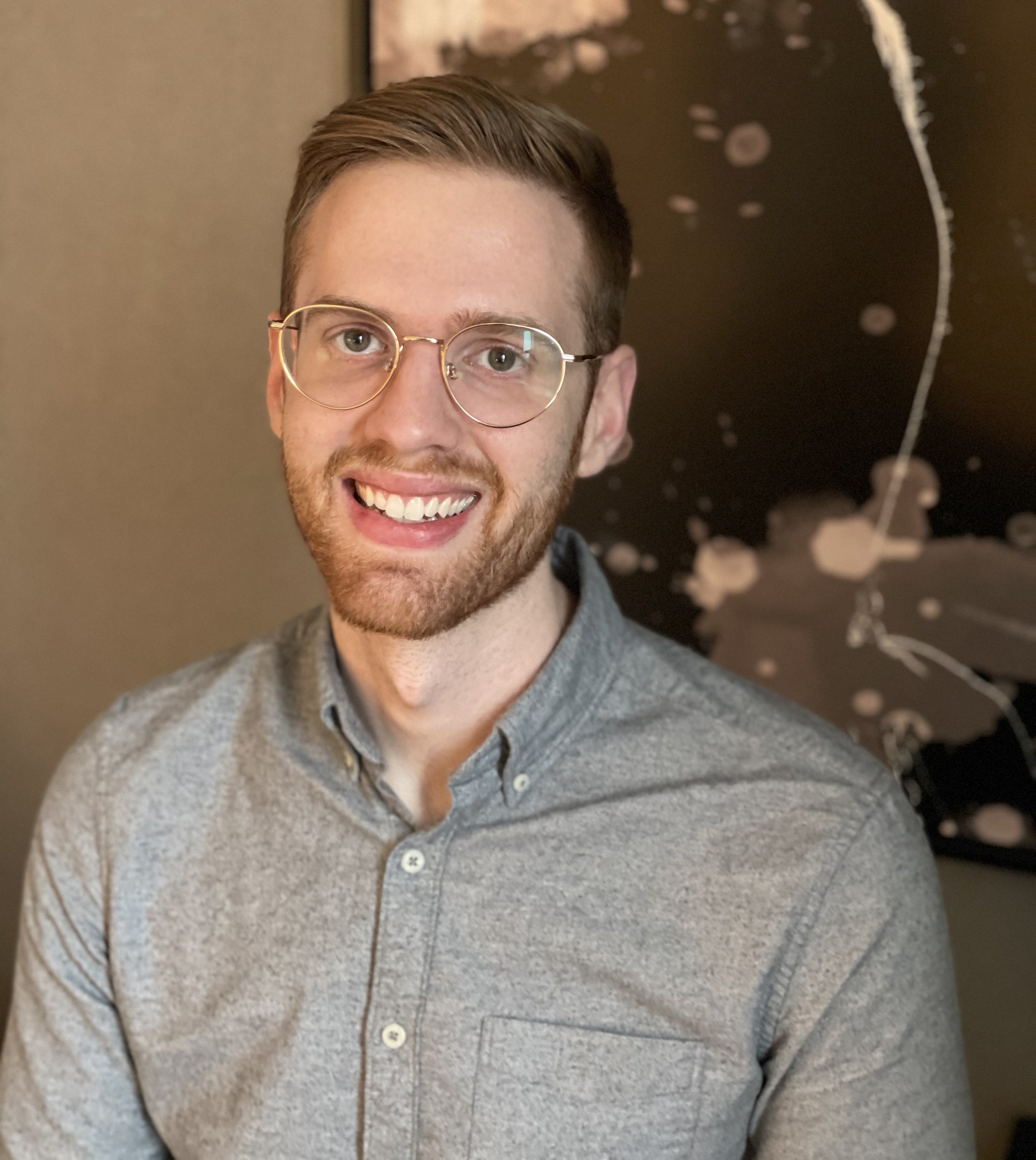 A blond man in glasses smiling