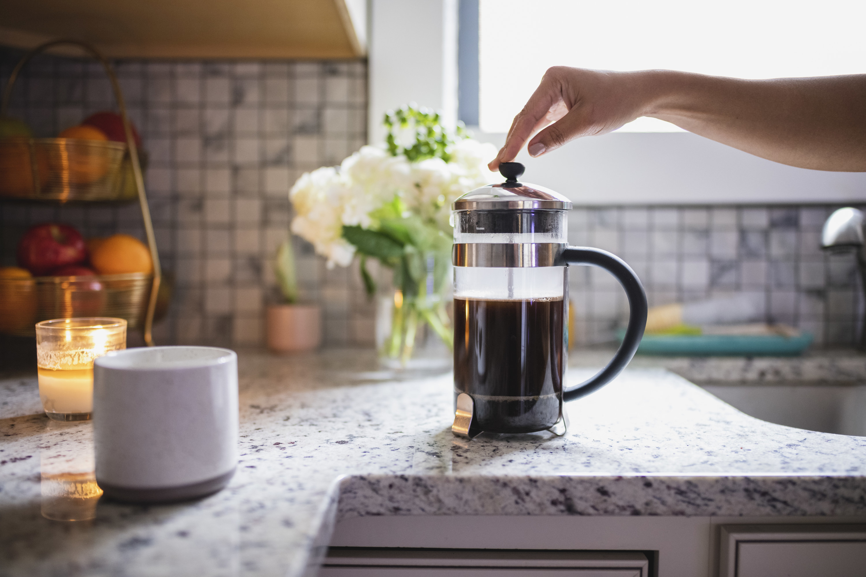 a french press and a mug on a kitchen counter