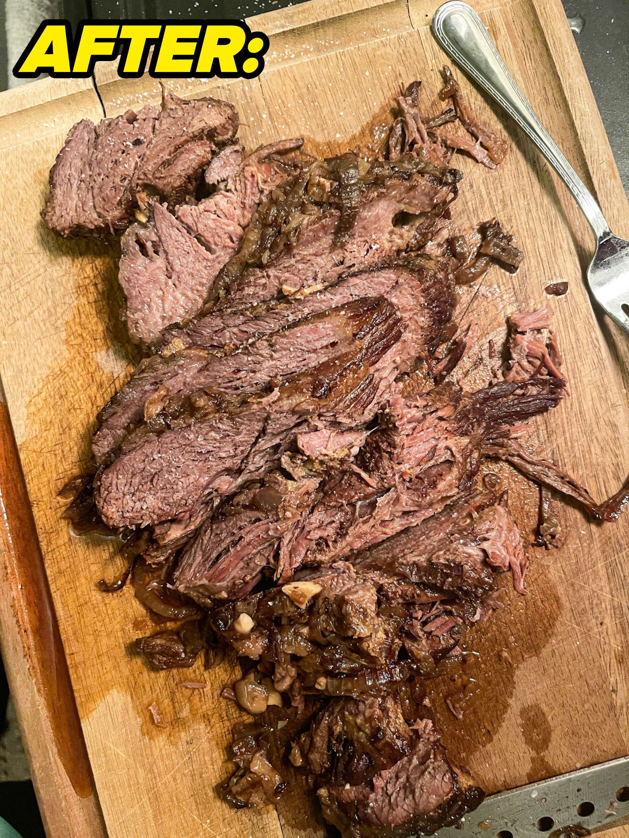 After: brisket sliced on top of a wooden cutting board