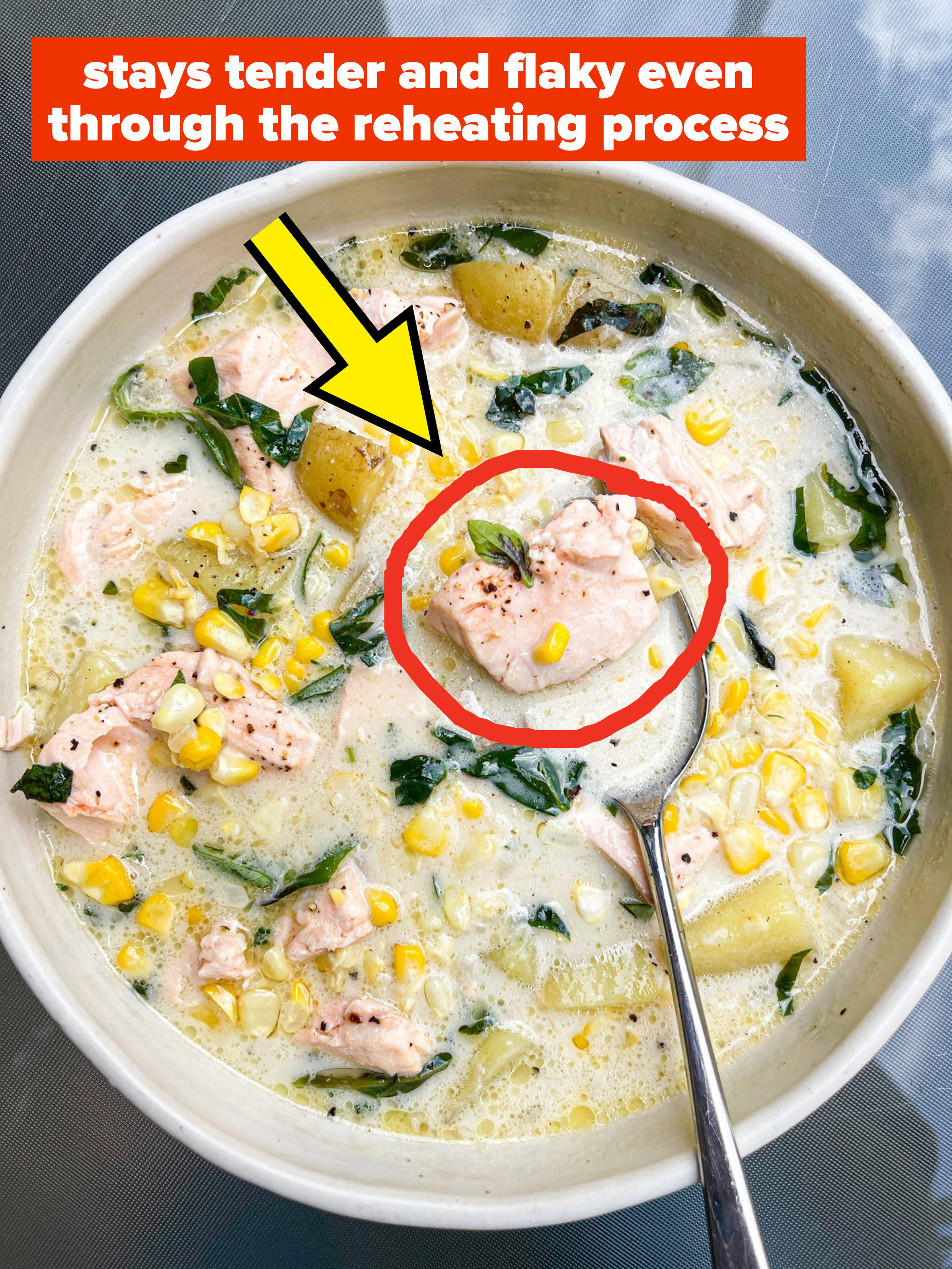 Chowder in a bowl with corn, greens, and flaky salmon that stays tender even through the reheating process