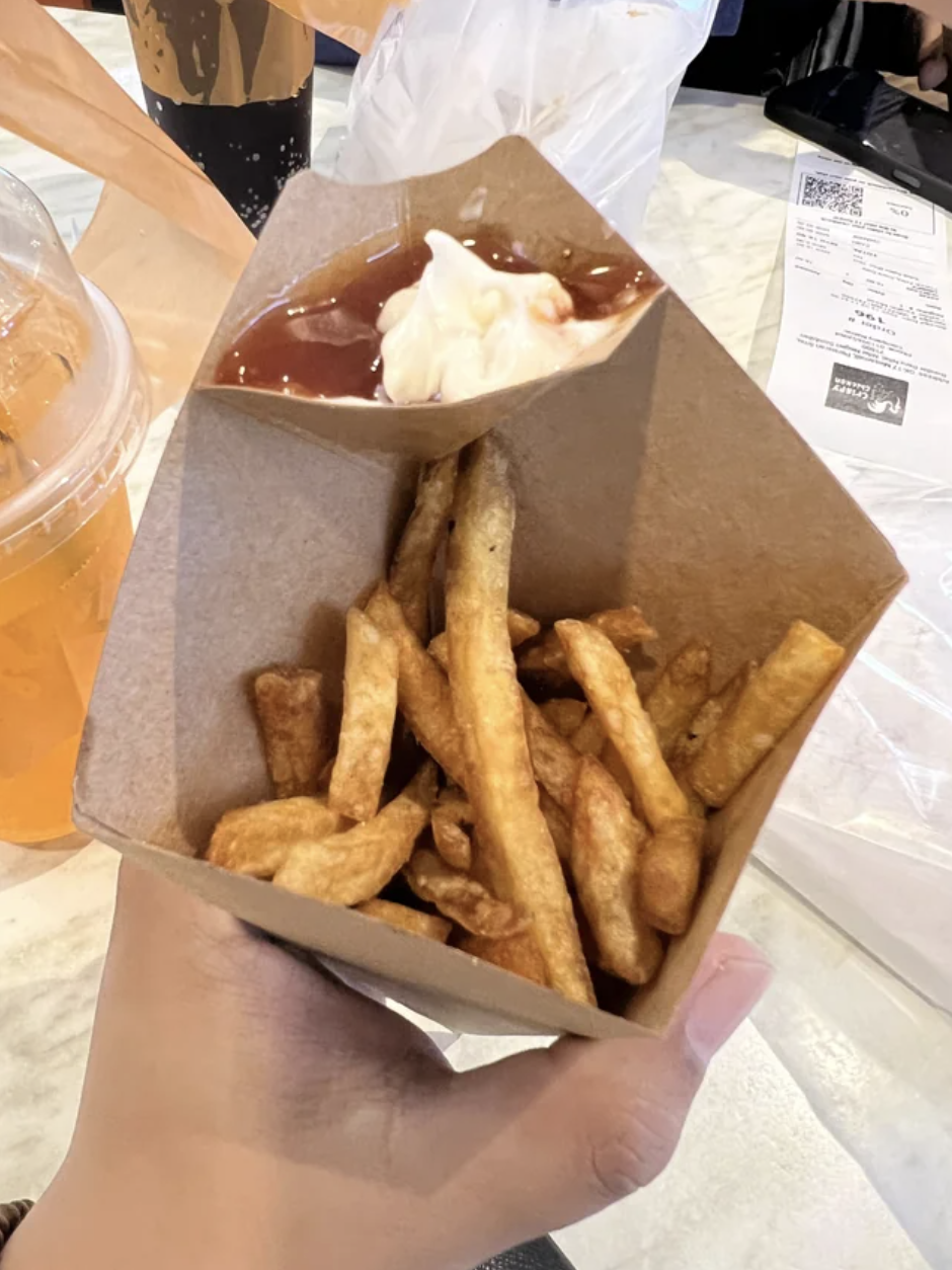 fries in a cone-shaped container with a lip for dipping sauce