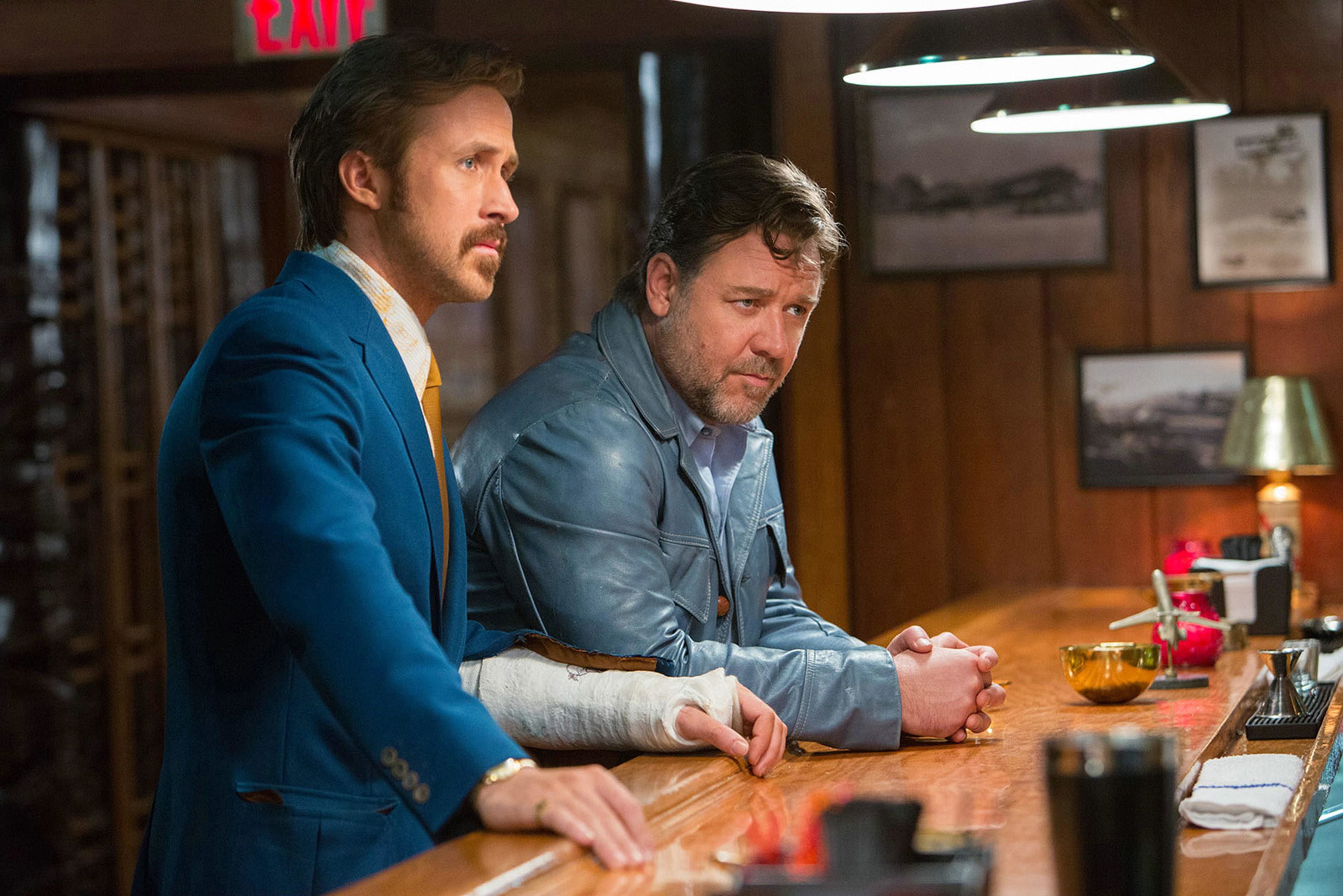 Ryan Gosling and Russell Crowe lean on a vintage bar