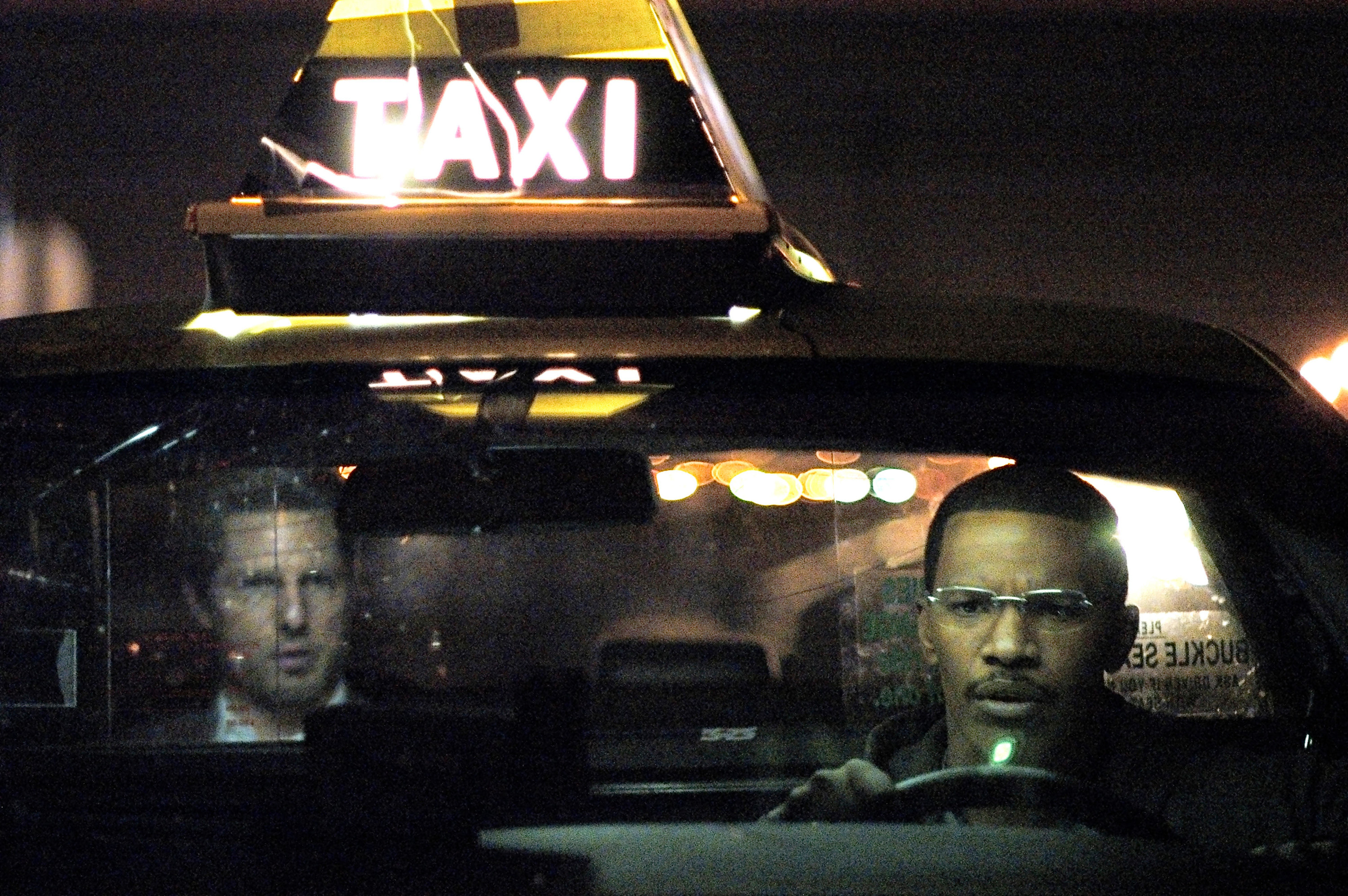 Tom Cruise and Jamie Foxx sit tensely in a taxi